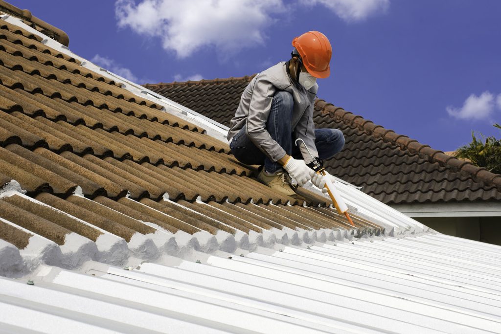 a man repairing roof of a house